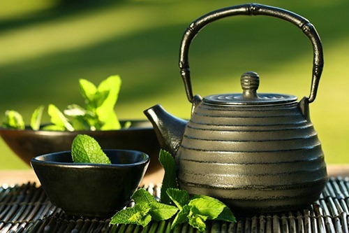 Black asian teapot with mint tea